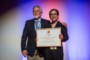 Man and woman on stage receiving prize
