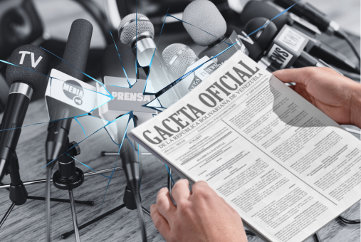A pair of hands holds a copy of the “Gaceta Oficial de la República Bolivariana de Venezuela,” while multiple microphones labeled with “TV,” “Media,” and “Prensa” surround the scene. A cracked glass effect overlays the image, symbolizing the impact of new regulations on the press and media.